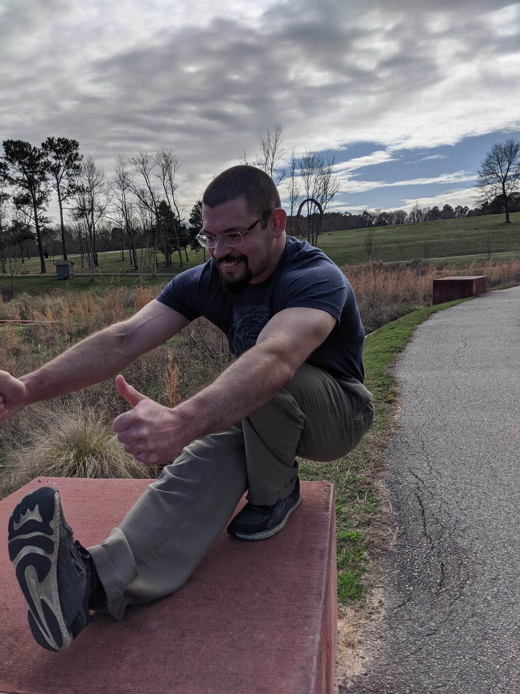 Coach Joe stretching outdoors on a bench